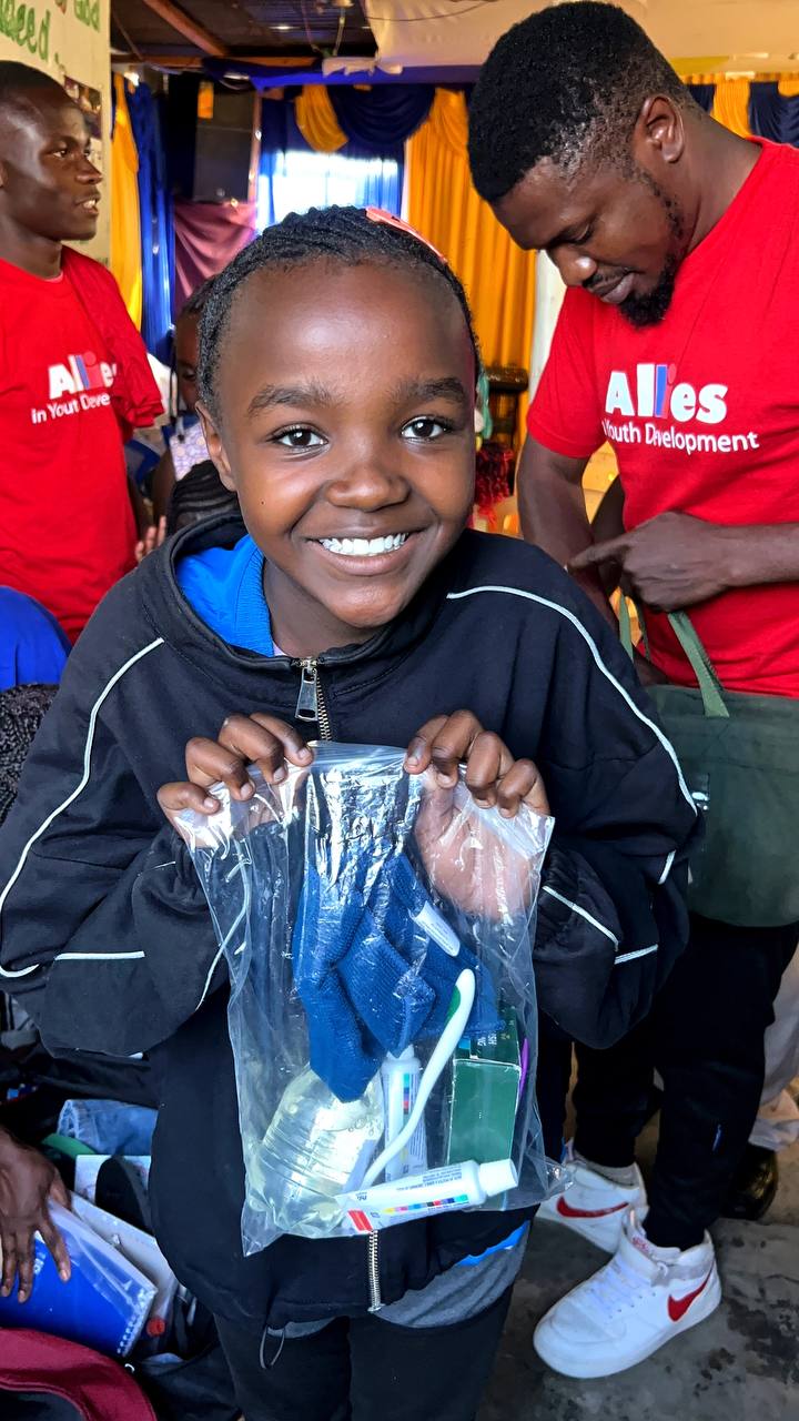 Child receiving hygiene kit through Allies collection drive